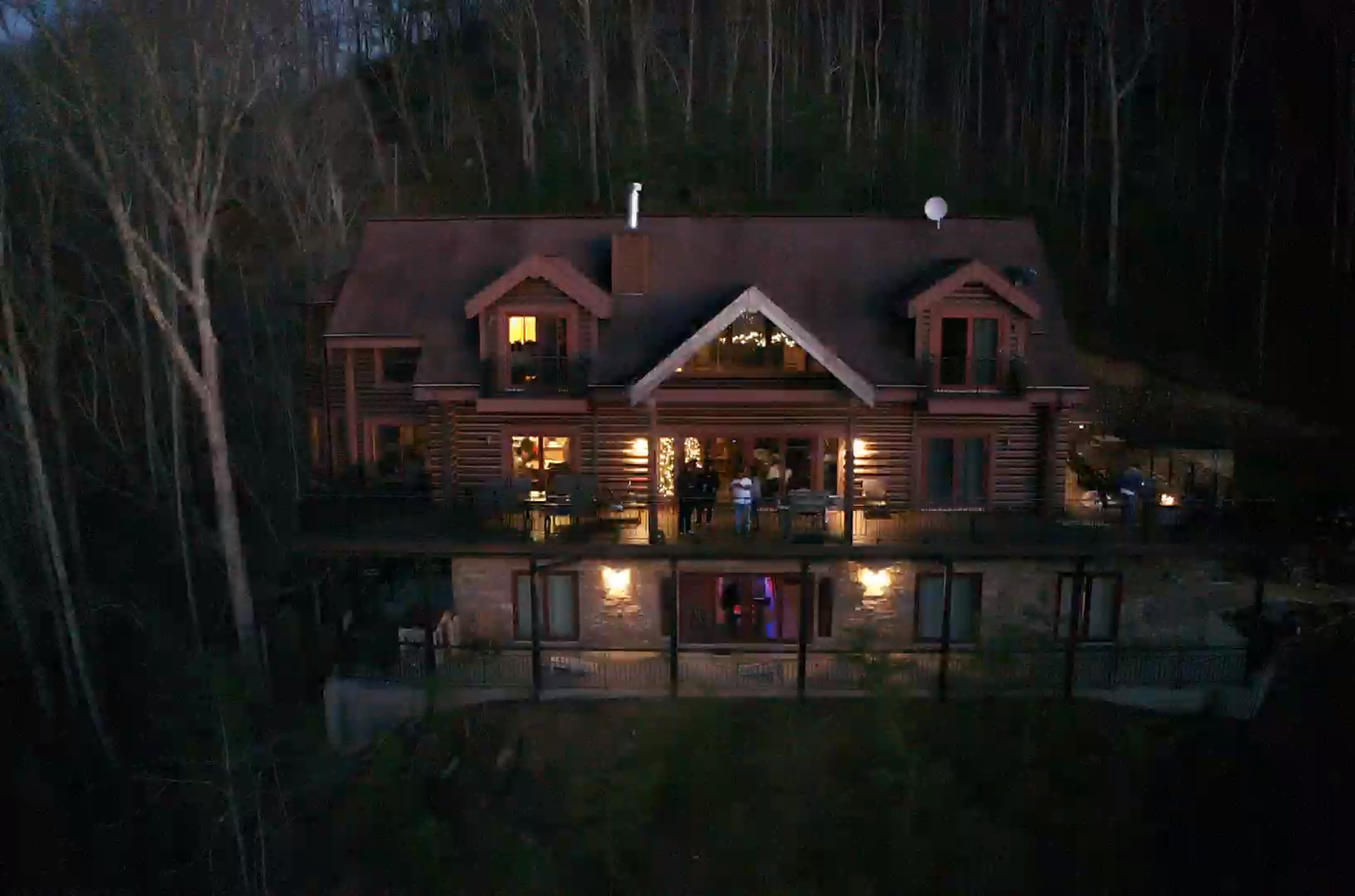 GATLANTA cabin at night with warm lights glowing from windows